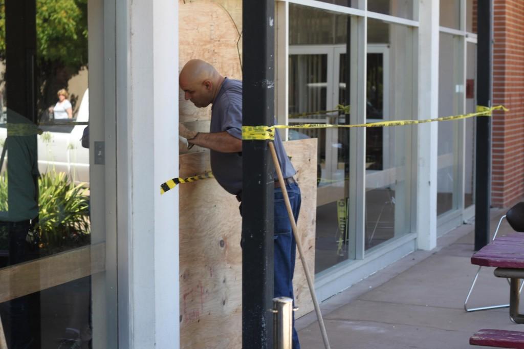 Central services worker Ron Dehelaita, 55, works on the broken Cafeteria window in the afternoon on August 25. (Pablo Caballero / The Inquirer)