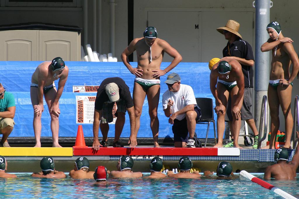 Coach John Roemer (tan hat) talks to the water polo team during a match earlier this season. (Pablo Caballero)