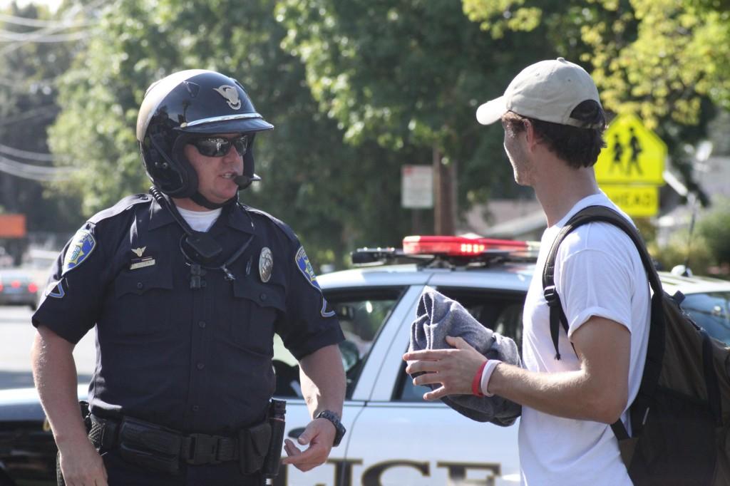 Philip Jenkins asks a Pleasant Hill police officer about the campus closure. (Danielle Barcena / The Inquirer)