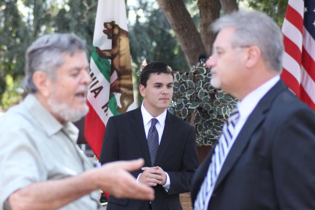 Alex Silva, center, Vice President of Legislative Affairs, anticipates the start of the 9/11 memorial while DVC President Peter Garcia, right, greets Amer Araim. (Danielle Barcena / The Inquirer)