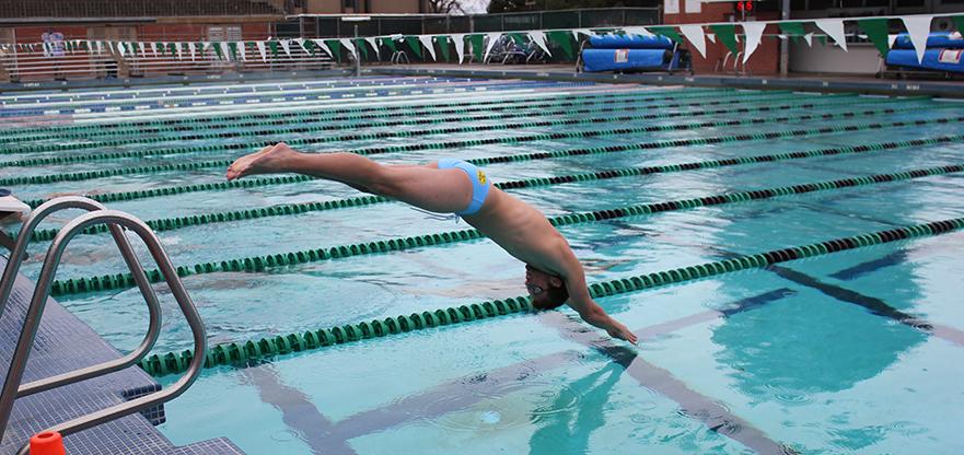 Taylor Martinez begins his warm-up routine in the rain. Part of the swimming/diving team, his specialty is 100 sprint, freestyle and fly.