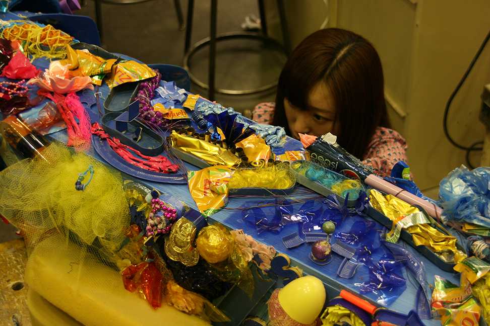 Meijing Liu, 21, works on arranging materials for the blue trash tree. (Theresa Marie/The Inquirer)