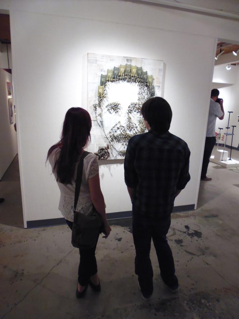 Art history students Travis Castro and Carol Trost observe Martin Segobias US Foreign Policy. (Julian Mark/ The Inquirer)