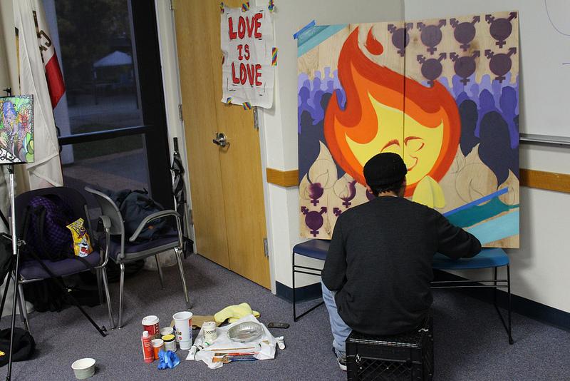 A student paints a mural during Transgender Remembrance Day.Photo credit: Daniel Barney.