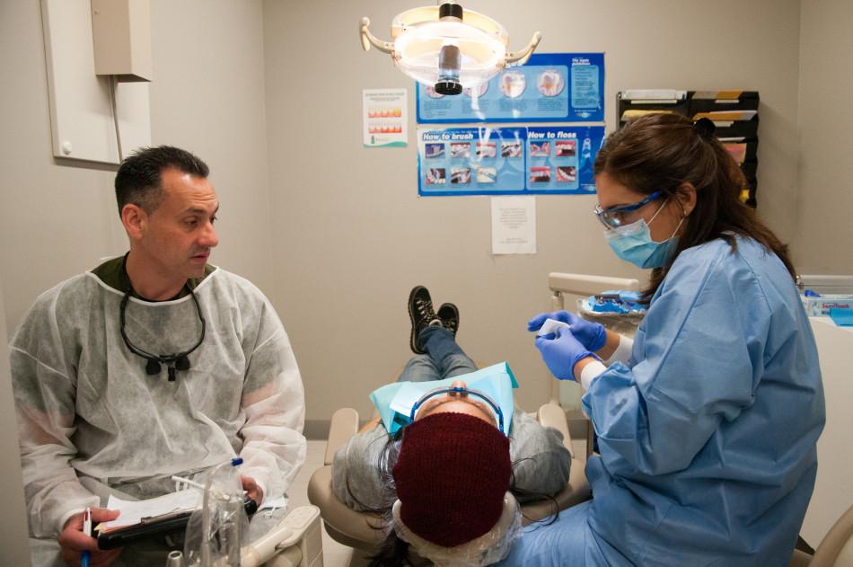 Dental hygiene student Bryan Pepperell and Dr. Jill Owens examining students teeth during an initial exam before being accepted for teeth cleaning on March 4, 2014. 