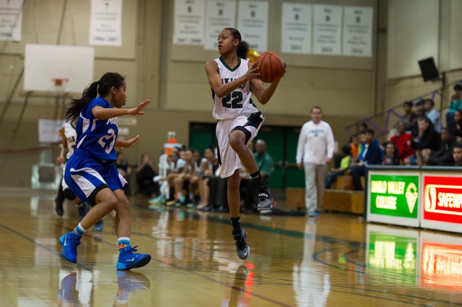 Adrianna Williams makes a pass around Modesto College player.  The Vikings win final home game 101-76 on Feb. 21, 2014.