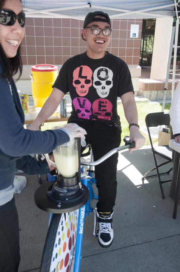 Leona Gee of the 511 Contra Costa holds down a blender full of lemonade and ice which is being crushed by the peddling of Diablo Valley College student Cristian Aragon on Tuesday, April 22, 2014 for Earth Day.