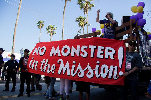 A speaker stands on the back of a truck giving a speech to a group of a few hundred protesters on Mission street in San Francisco during the May Day protests on May 1, 2015