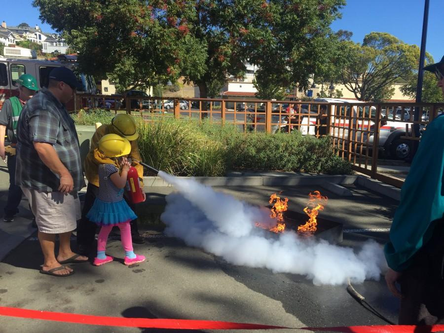 Firefighters help children with a fire extinguisher demo at Benicia Fire Departments Open House Oct. 10.