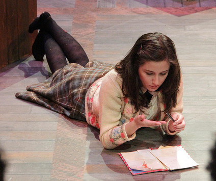 Anne Frank, played by Tamara Hurwitz, writes in her diary in the DVC production of The Diary of Anne Frank opening Dec. 4