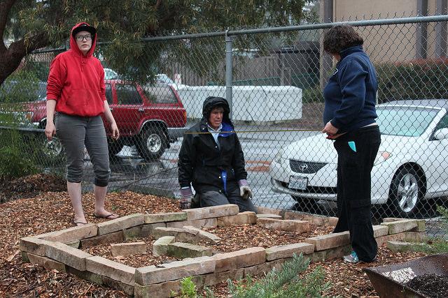 Horticulture club members Mercy Garetz (left) and Teresa Conroy (right) and professor Frank Kluber (center) prepare a raised bed for the horticulture plant sale, Feb. 19