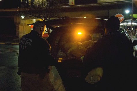 Doug Stewart from the Contra Costa County Homeless Outrach Program checks in with a homeless man and gives him some food and blankets at the Concord Bart station in Concord on 5 March.