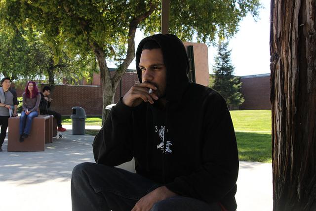 Music industry studies major Darryl Hall passes time with a smoking break near Police Services on DVC campus, Thursday, March 31.