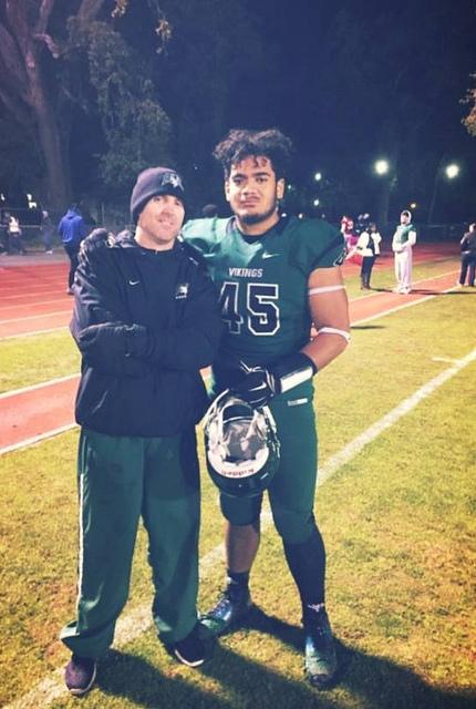 Coach Darr and Franklin Uesi on the field of Viking Stadium after a wining game. 