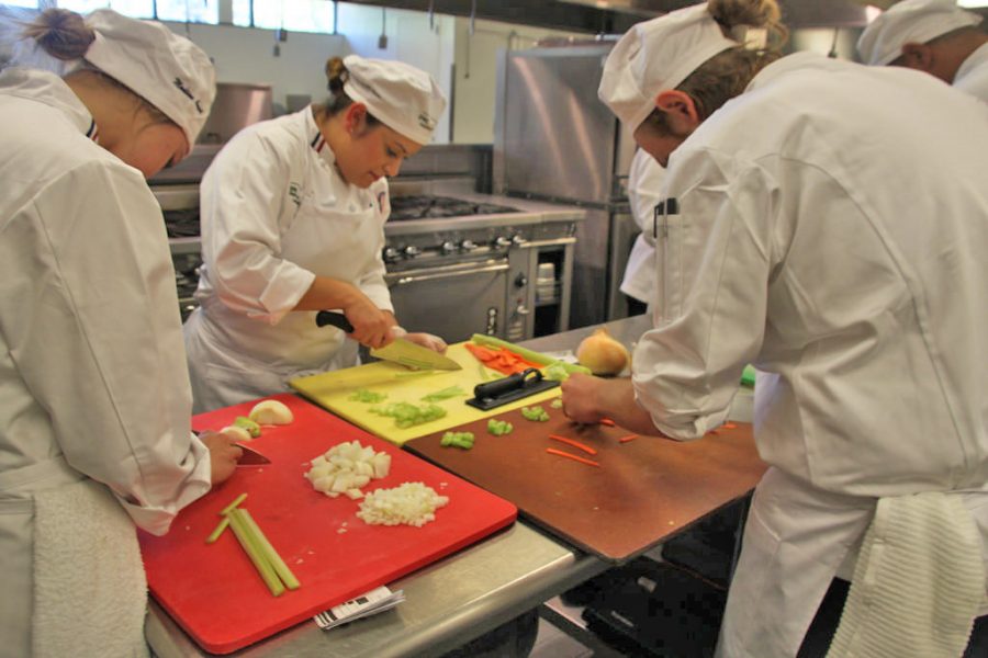 Baking and pastry majors Zach Matera, 22, Norine Wan, 27, and Madison August, 20 work away perfecting their various cuts and dices in the DVC culinary class.