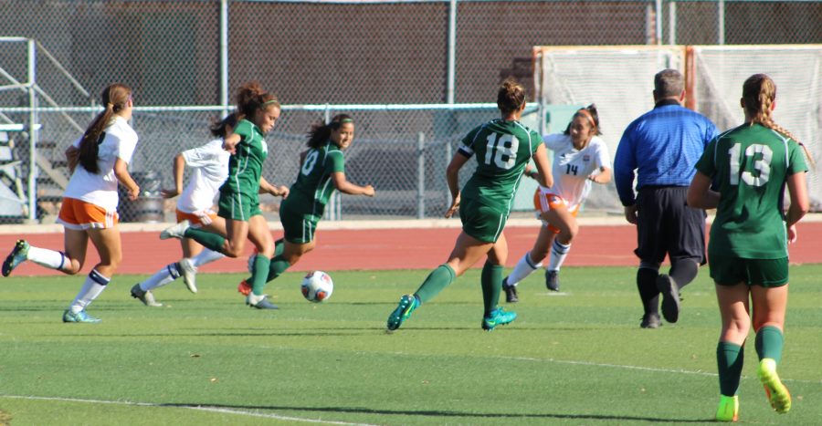 Karla Ramos kicking the ball with teammates Vanessa Ruvalcaba, Megan Melara and Chloe Lindemann playing against Cosumnes River College on the Vikings football field on Oct.18.