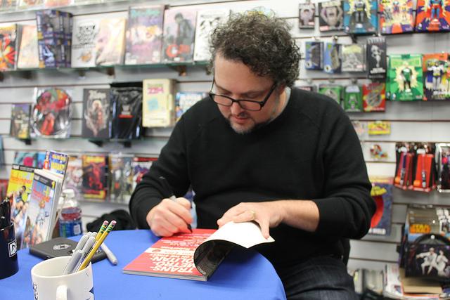 Comic book artist Darick Robertson autographs his work at Flying Colors Comic Book Store during a meet and greet on November 19, 2016.