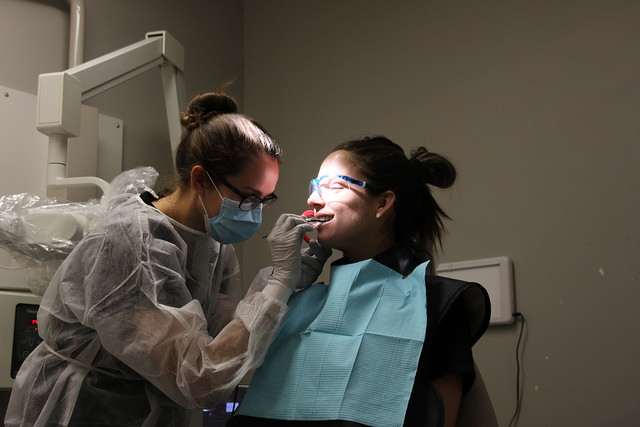 Rachel Alvernaz, senior Dental Hygene student, works on Haley McDonough, Junior Dental Hygene student.