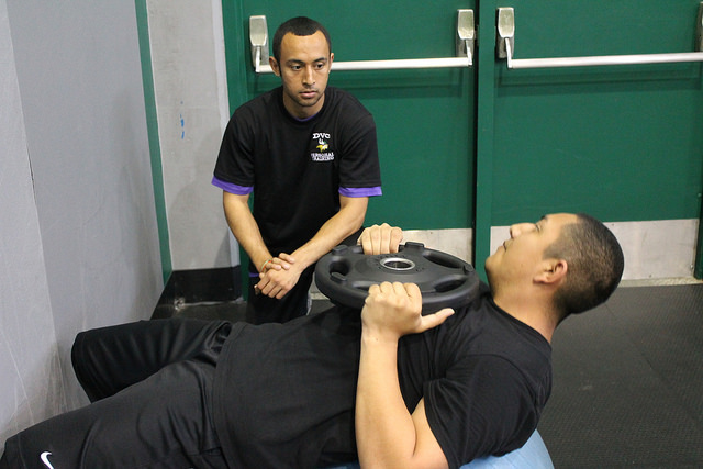 Ty Piona, kinesiology major, works with a student in the gym on March 16, 2017.