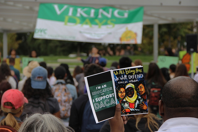 People hold up flyers at a DACA rally held at Diablo Valley College on Sept. 7, 2017.