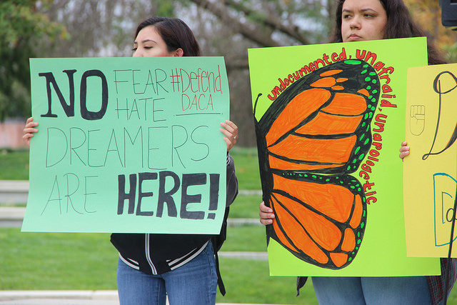 Students stand is support as speakers share their stories about immigration. Sep. 7, 2017