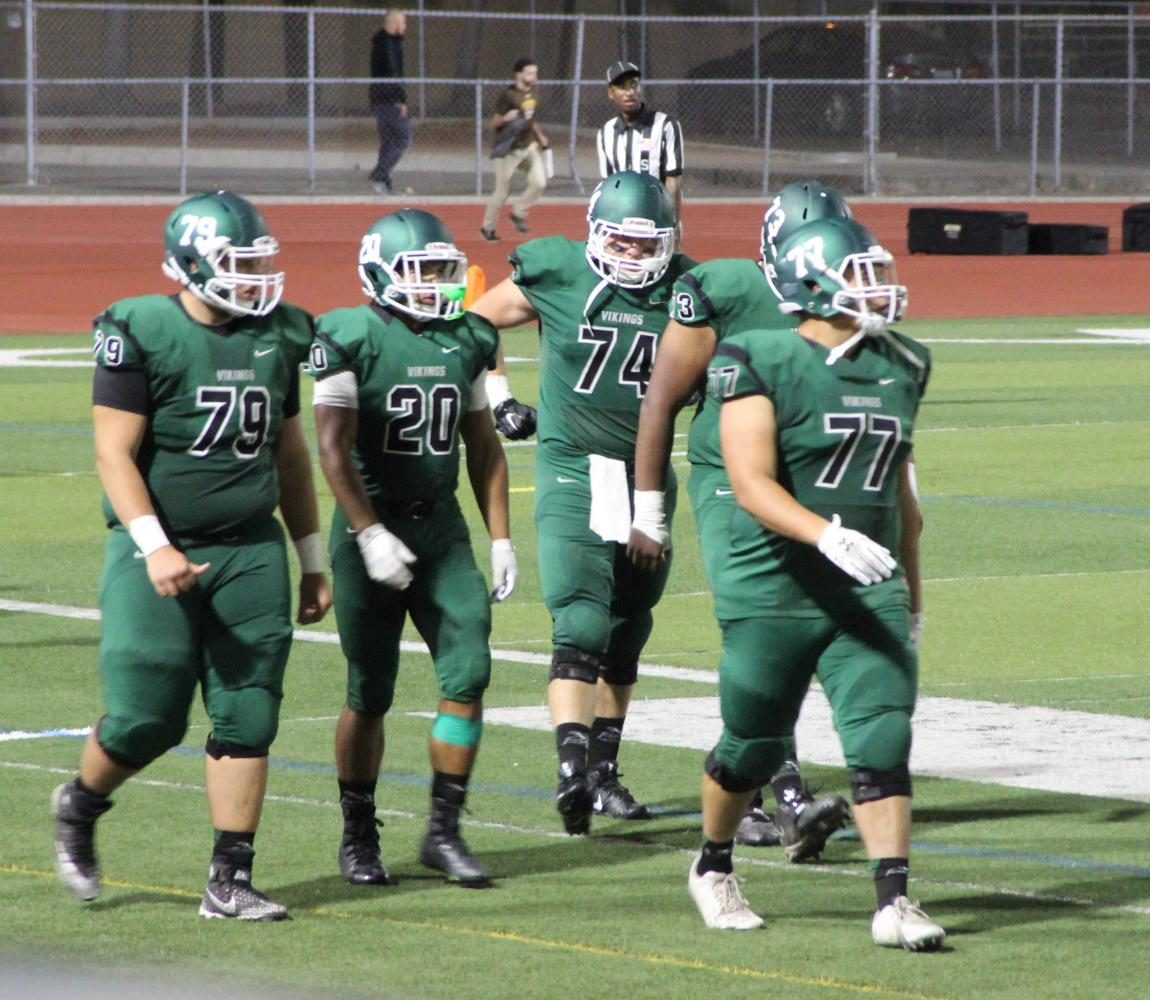 Running back Gabriel Watson #20 walks on the sideline with members of his offensive line before the second half kickoff at Viking Stadium on Friday, September 8, 2017.