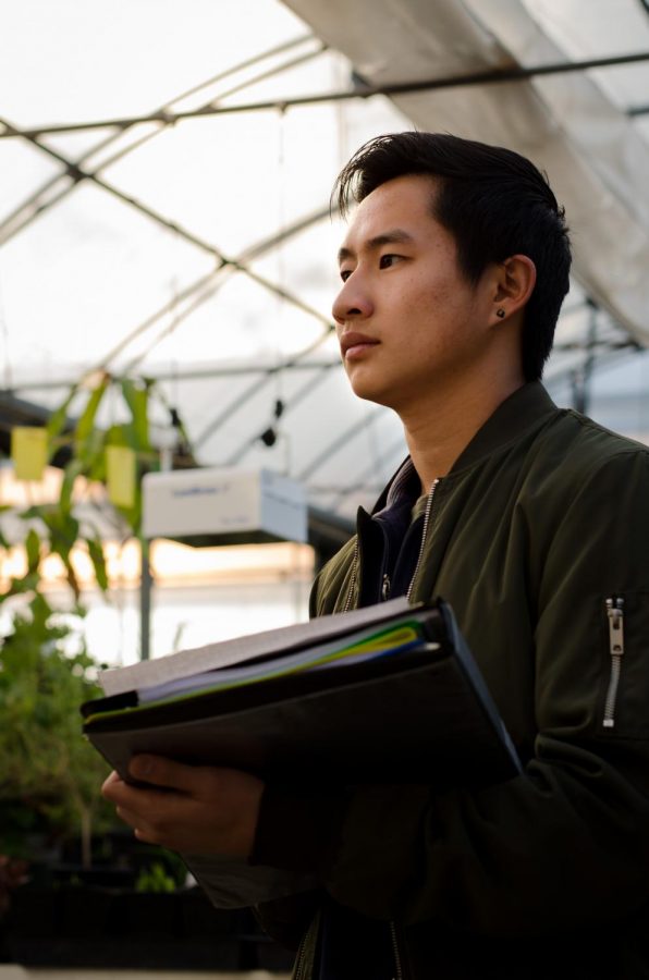 Brandon Chan, engineering student, 22, creates a to do list for the Vertical Farming Club in a greenhouse at the DVC Horticulture area on Thursday, Feb. 23rd. He, and the rest of the club, are creating a sustainable vertical farming system to grow vegetables in layered beds.