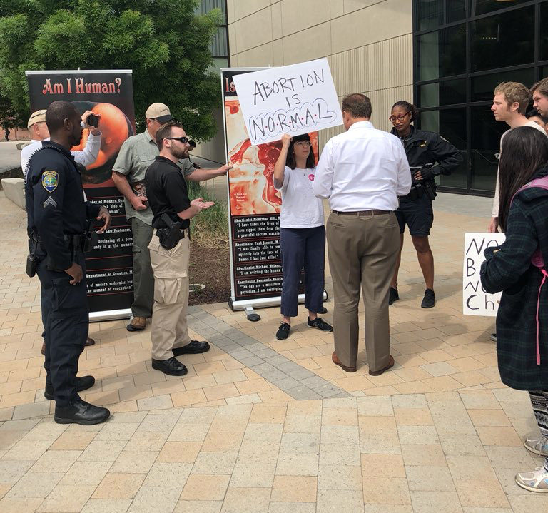 Rhianna Taylor refuses to move from in front of pro-life banners in the DVC commons, April 10.