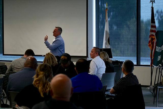 An attendee asks one final question before the meeting breaks for small groups. 