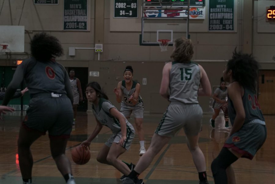 Players on the DVC womens basketball watch as guard Jasmine Kong (center left) dribbles towards the basket during the match against Sacramento City at DVC on January 8th, 2019. 