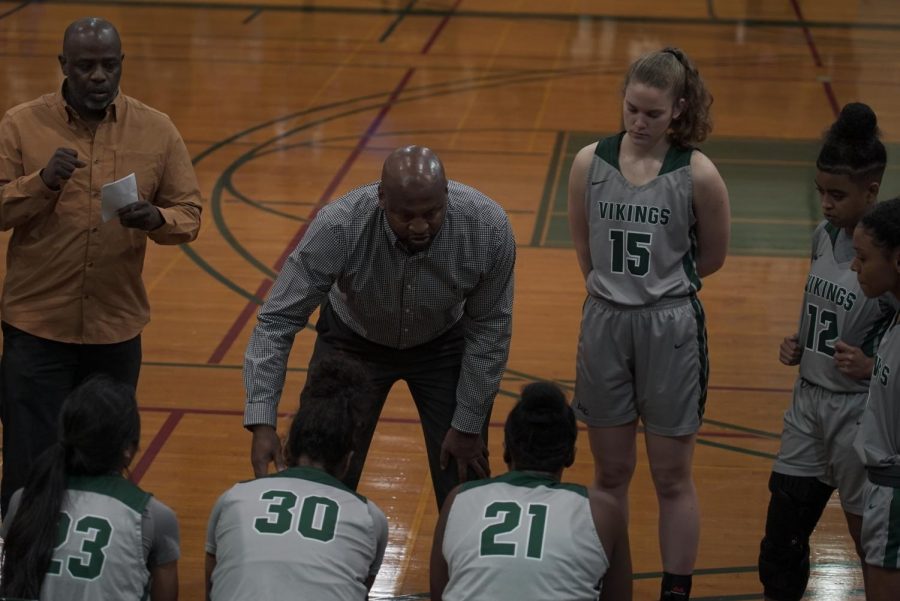 Head coach Ramaundo Vaughn (center) and assistant coach Kameo Williams (left) talk with players in a timeout during the match against Sacramento City at DVC on January 8th, 2019. (Ethan Anderson/Inquirer)